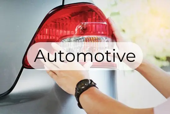 Text reading "Automotive" over a background of a taillight assembly on a car